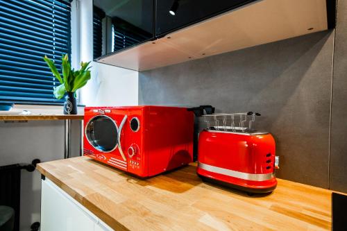 un forno a microonde rosso seduto sopra un bancone della cucina di Apartament P&B a Rybnik