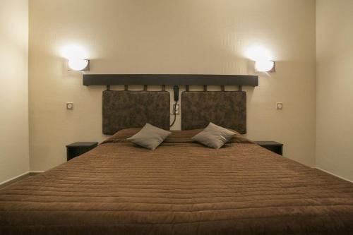 a bedroom with a large bed with two pillows at Hotel du Col d'Osquich in Musculdy