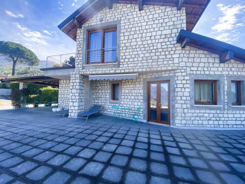 a house with a patio in front of it at Vela di Soleville camere con e senza vista lago con ristorante & pizzeria in Sale Marasino