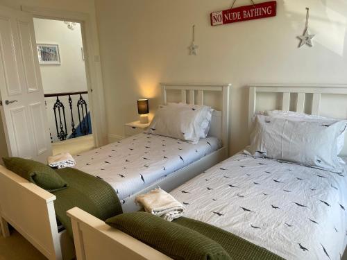 two beds sitting next to each other in a bedroom at Sandy Toes - awesome beach view and access in Ventnor