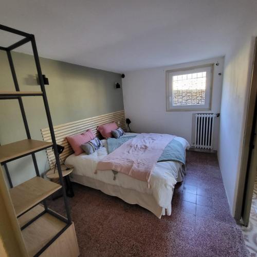 a bedroom with a bed with pink pillows on it at Les Pierres de Cézaire in Saint-Cézaire-sur-Siagne