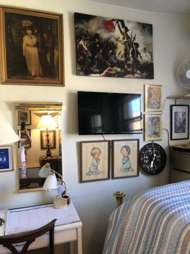 a bedroom with paintings on the wall and a desk at Highland Park Pittsburgh in Pittsburgh