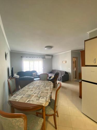 een kamer met een tafel en stoelen en een woonkamer bij Saranda relax apartments in Sarandë