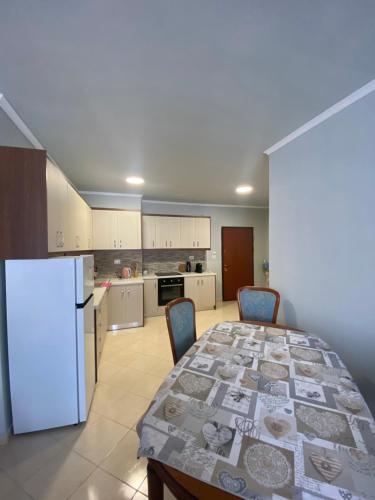 een keuken met een tafel en een witte koelkast bij Saranda relax apartments in Sarandë