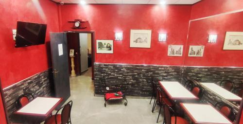 a dining room with red walls and tables and chairs at Hôtel Moderne in Saint-Denis