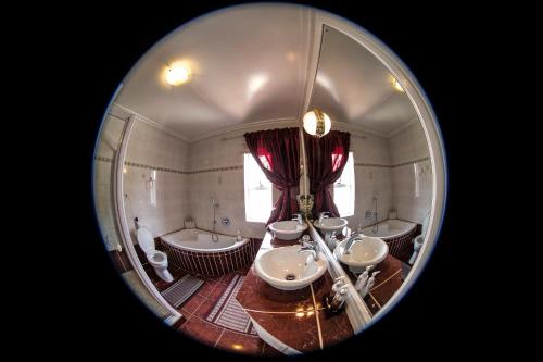 a bathroom with four sinks and two tubs and a mirror at Arista Guesthouse in Bloemfontein