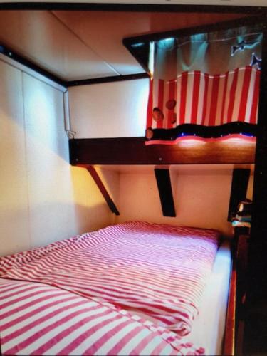 Letto a castello con piumone a righe rosse e bianche di Schiff AHOY, Hotelschiff, Hausboot, Boot, Passagierschiff a Stoccarda