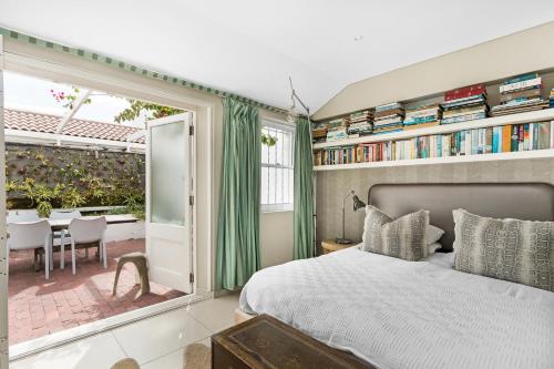 a bedroom with a large bed and a patio at Kleinbaai Cottage on the Sea in Cape Town