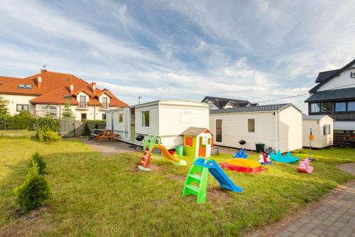 een tuin met kinderspeelplaats voor een huis bij Jarosławiec domki letniskowe -300m od morza in Jarosławiec