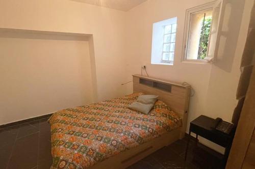 1 dormitorio con cama con edredón y ventana en RIVA BELLA villa plage, en Bandol