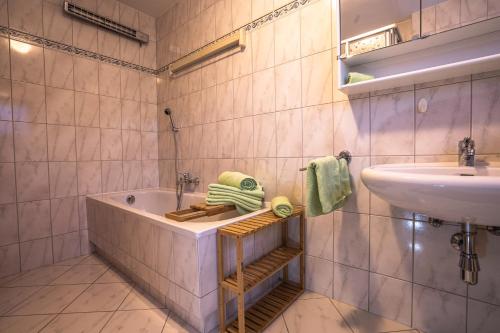 a bathroom with a sink and a bath tub and a sink at Chalet Obenland Kitzbühler Alpen in Bramberg am Wildkogel