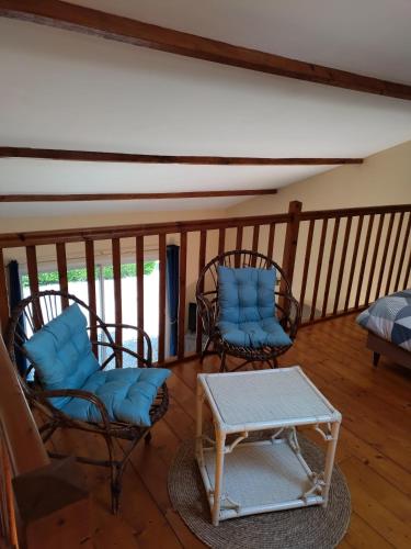 a room with two chairs and a table on a balcony at Gîte berneval le grand in Berneval-le-Grand