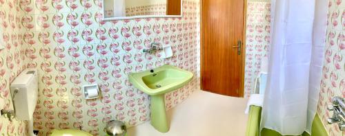a bathroom with a green sink on the wall at Carpenter's House in Skala Sotiros