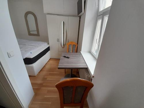 ein kleines Zimmer mit einem Tisch, Stühlen und einem Bett in der Unterkunft Classic Appartments in Knittelfeld