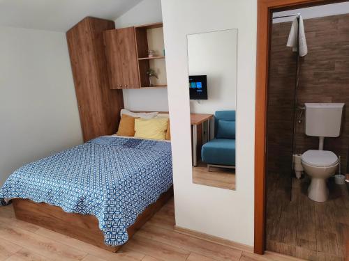 a bedroom with a bed and a toilet and a mirror at iVAVƏV byTheSea in Constanţa