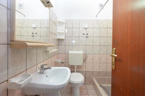 y baño con lavabo, aseo y espejo. en Apartments Lavanda 108, en Fažana