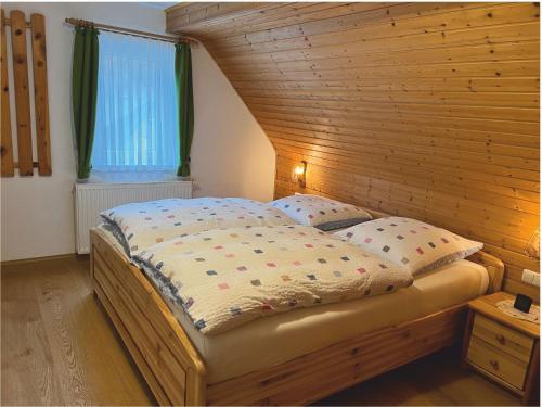 a bedroom with a bed with a wooden wall at 4 Sterne Ferienwohnung Sommerberg in Rohrbach