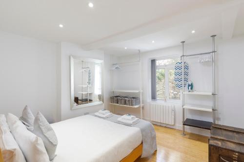 um quarto branco com uma cama e uma janela em Spacious central Hove 1-bed flat em Brighton & Hove