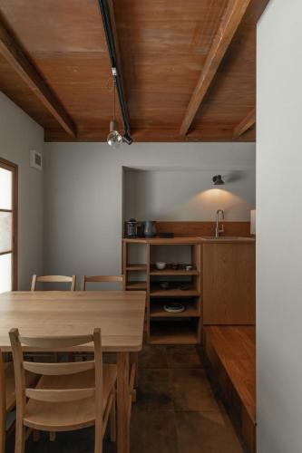 a dining room with a wooden table and chairs at 長浜城下 町屋ホテル 和乃リトリートひといき in Nagahama
