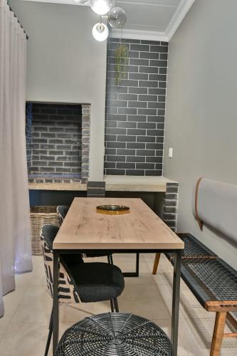 a dining room with a wooden table and chairs at Summer PALACE Guesthouse in Bloemfontein