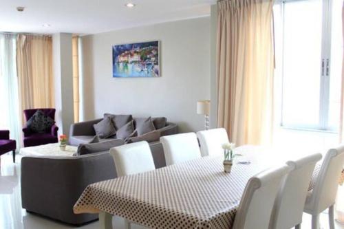 a living room with a couch and a table and chairs at The Vimanlay Beachfront Condo Retreat 3rd Floor in Cha Am