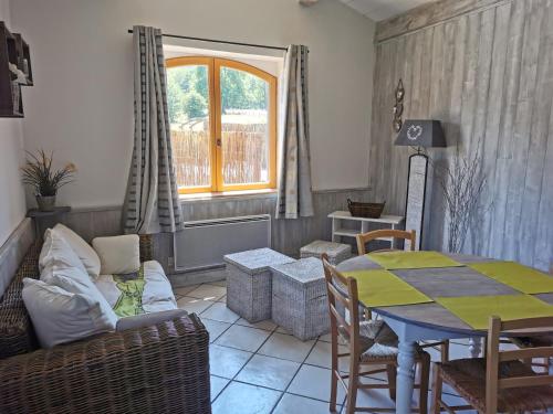 - un salon avec un canapé et une table dans l'établissement Le Moulin de la Fortie, Gîtes, à Viscomtat