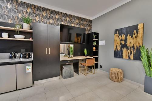 a kitchen with a table and a desk in it at Summer PALACE Guesthouse in Bloemfontein