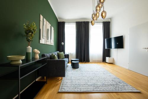 a living room with green walls and a couch at Brand-new apartment with a breathtaking design located right near Belvedere Castle, 15 minutes from city centre in Vienna