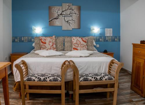 a bedroom with a bed with two chairs at Hotel Sol del Sur in Esquel