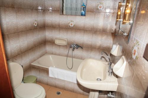a bathroom with a toilet and a sink and a tub at Villas Michalis in Chorafakia