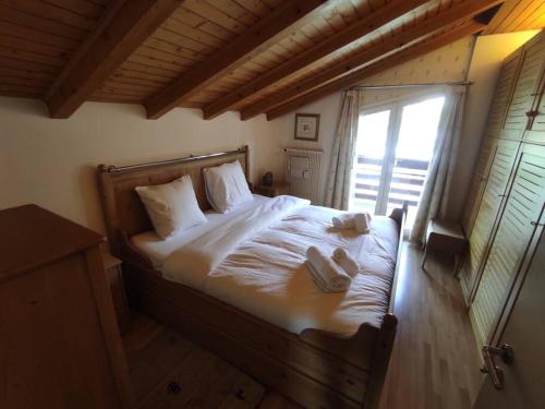 a bedroom with a bed with white sheets and a window at Attic Gem with Unbeatable Lake Moubra View in Crans-Montana