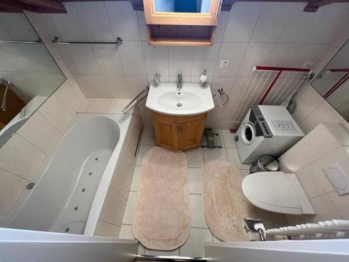 a bathroom with a sink and a tub and a toilet at Attic Gem with Unbeatable Lake Moubra View in Crans-Montana