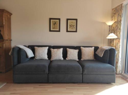 a blue couch in a living room with pillows on it at Attic Gem with Unbeatable Lake Moubra View in Crans-Montana