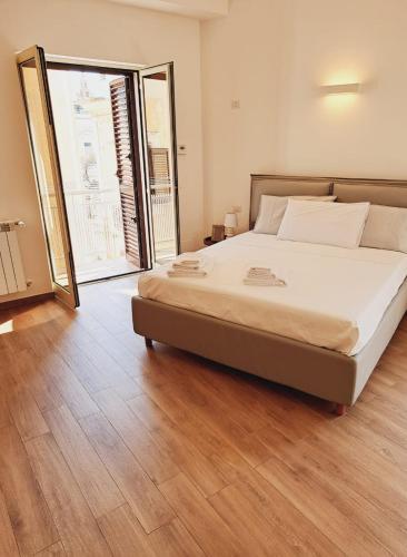 a bedroom with a large bed and a wooden floor at M. Szwed. Guest House old Bari in Bari