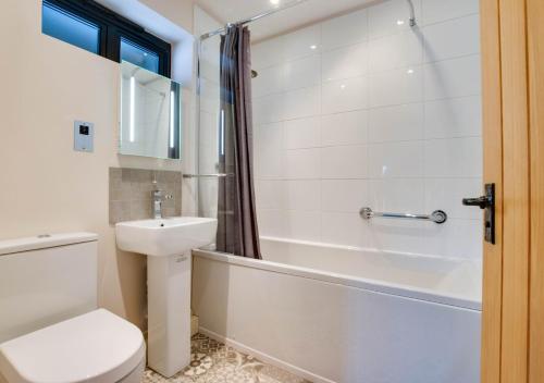 a bathroom with a toilet and a sink and a bath tub at 3 Hilltop Cottages in Stansted
