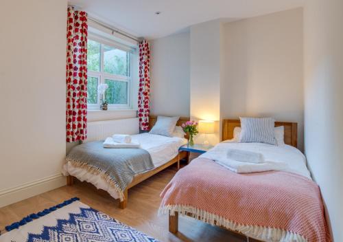 a bedroom with two beds and a window at Beachside Hideaway in Broadstairs