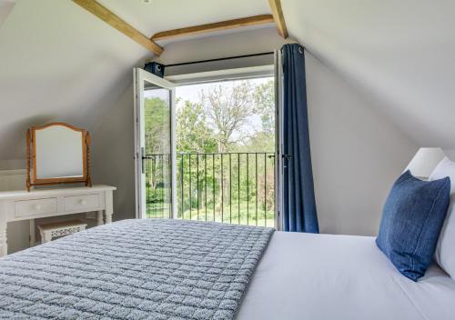 a bedroom with a bed and a large window at Bewl Water View in Ticehurst