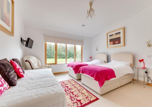 a bedroom with two beds and a window at Apple Barn in Lyminge