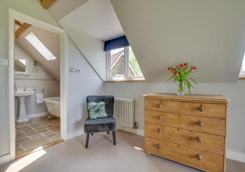 a bathroom with a dresser with a vase of flowers on it at Bewl Water View in Ticehurst