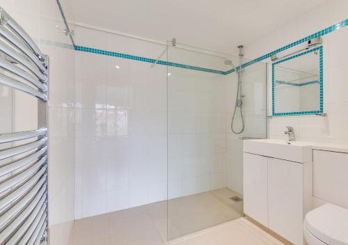 uma casa de banho branca com um chuveiro e um lavatório. em Apple Barn em Lyminge