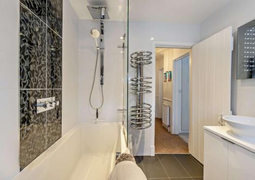 a bathroom with a bath tub and a sink at Beachtown Cottage in Broadstairs