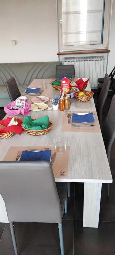 a table with chairs and plates and food on it at B&B Casa Lilla in Verzuolo