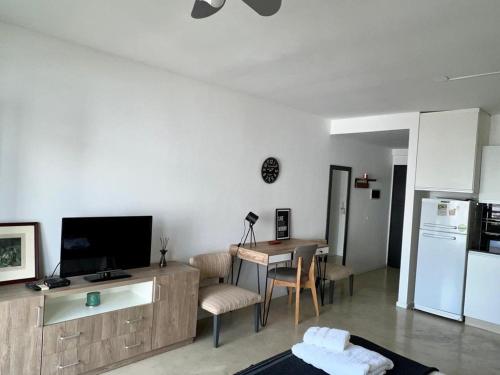 sala de estar con TV y mesa y cocina en Great Studio in Palermo Soho 2PAX en Buenos Aires