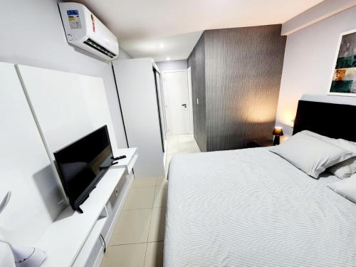 - une chambre avec un lit et une télévision à écran plat dans l'établissement Cobertura em Ondina, à Salvador