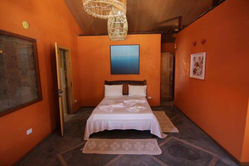 una camera arancione con un letto di Casa de Maria na Praia de Atins ad Atins