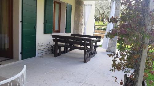 a wooden bench sitting on the porch of a house at Casaliva Relais in Bardolino