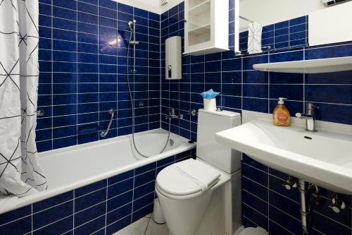 a blue tiled bathroom with a toilet and a sink at BRN Bootsmann in Laboe