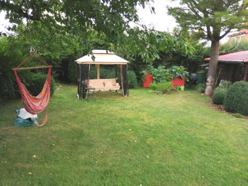 a hammock in a yard with a gazebo at Ferienwohnung Varmissen in Dransfeld