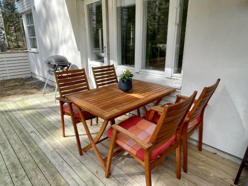 - une table et des chaises en bois sur une terrasse couverte dans l'établissement Cozy apartment with sauna & terrace, à Hyvinkää