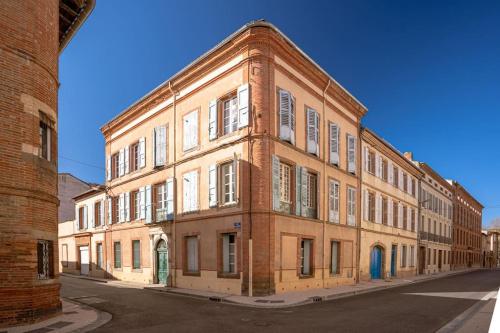 a large brick building on the side of a street at L'Oasis - Charme et confort au centre-ville in Albi